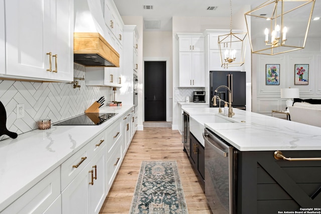 kitchen with white cabinets, visible vents, a sink, black appliances, and custom range hood