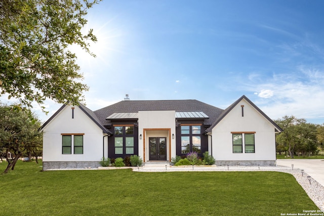 modern farmhouse style home with stucco siding, a front lawn, a standing seam roof, and metal roof