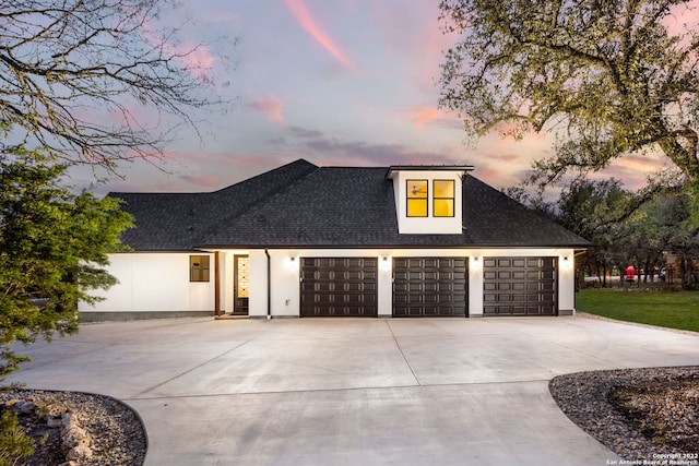 view of front facade featuring a garage, stucco siding, roof with shingles, and concrete driveway