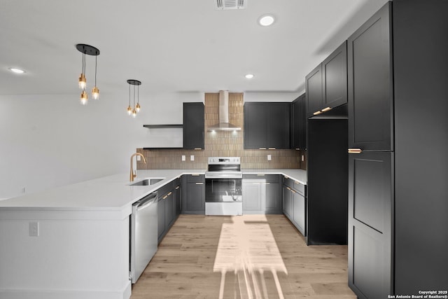 kitchen with wall chimney exhaust hood, a sink, recessed lighting, open shelves, and appliances with stainless steel finishes