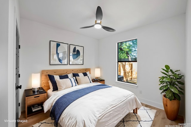 bedroom featuring light wood-style floors, baseboards, and ceiling fan