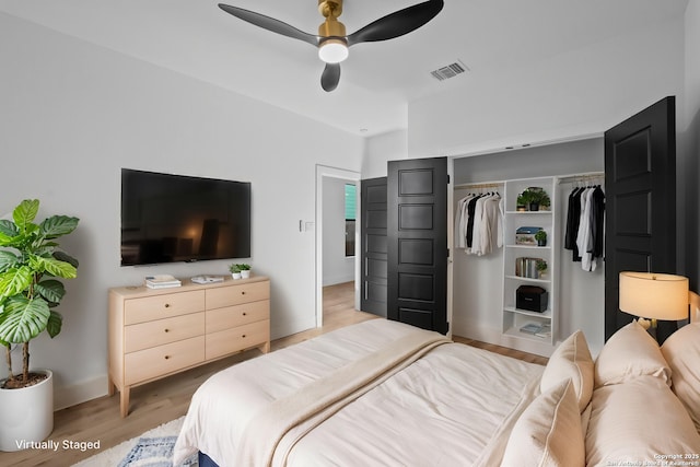 bedroom featuring a closet, light wood-style floors, ceiling fan, baseboards, and visible vents