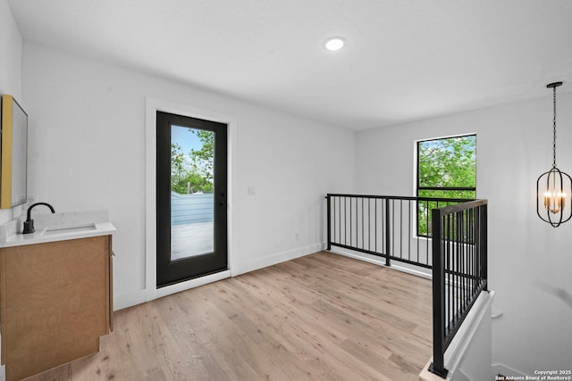 interior space featuring a wealth of natural light, a chandelier, light wood-style floors, and baseboards