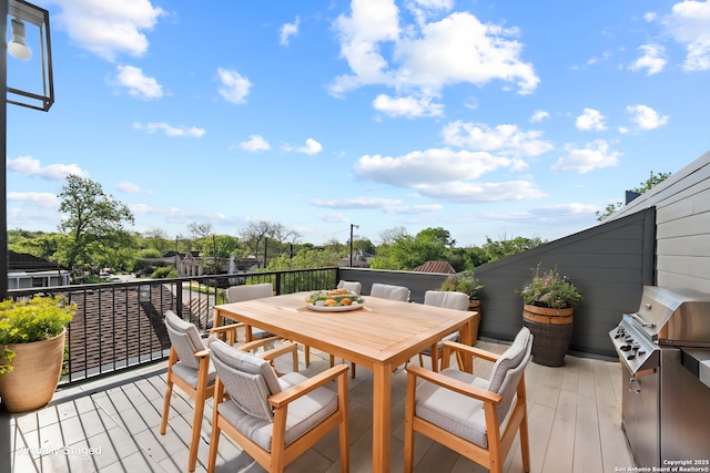 wooden deck with outdoor dining area and area for grilling