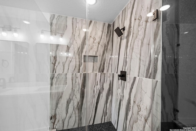 full bathroom with a textured ceiling and a marble finish shower