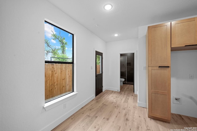 corridor featuring baseboards, light wood-style floors, and recessed lighting