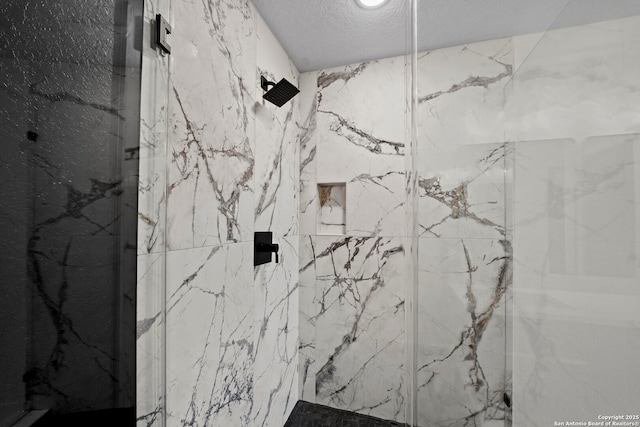 bathroom featuring a marble finish shower