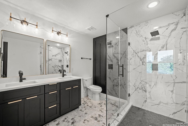 full bathroom with visible vents, a sink, a marble finish shower, and toilet