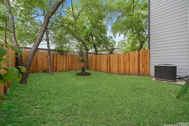 view of yard featuring a fenced backyard and central AC