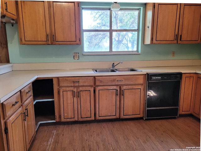 kitchen featuring black dishwasher, a sink, brown cabinets, and plenty of natural light