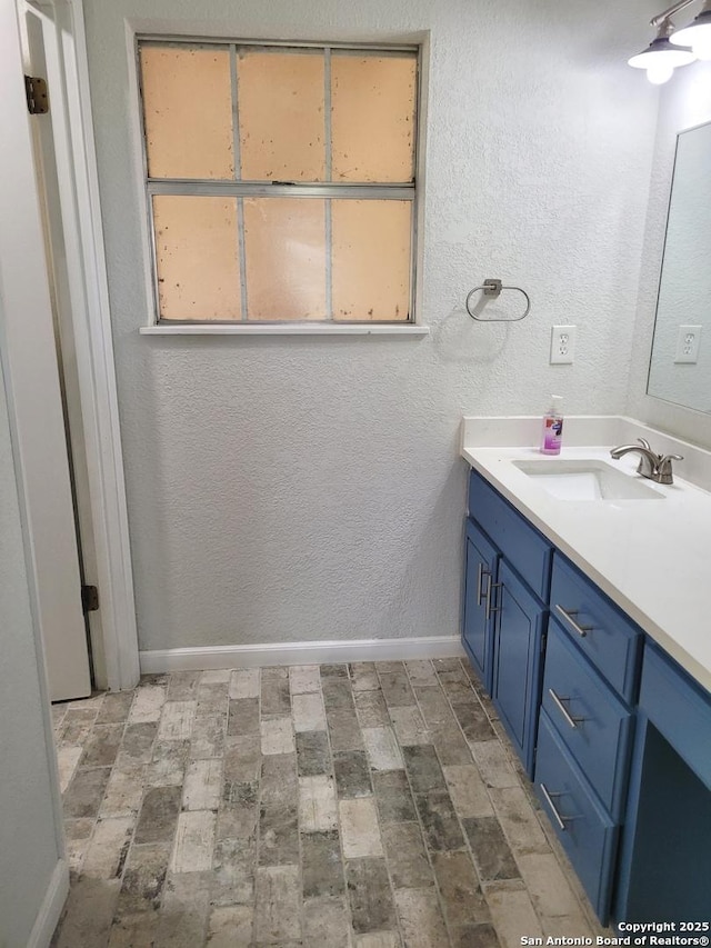 bathroom with brick floor, baseboards, and vanity