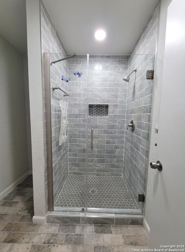 full bath with baseboards and a stall shower