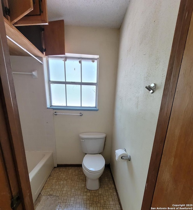 bathroom featuring toilet, a textured ceiling, and baseboards
