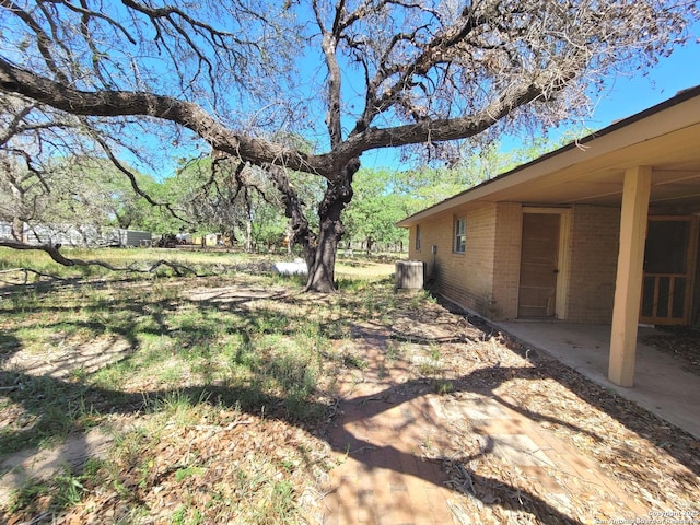 view of yard with central AC and a patio area