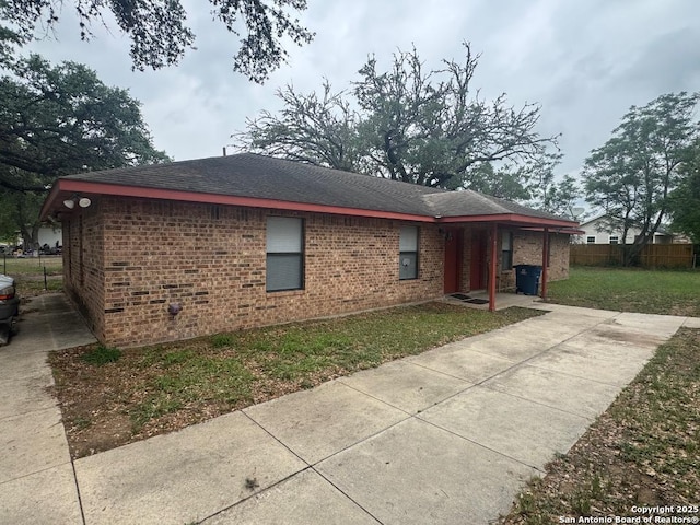 823 Dallas, Pleasanton, TX 78064 - exterior space featuring fence, a lawn, a shingled roof, and brick siding