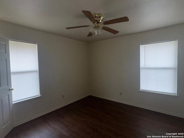 823 Dallas, Pleasanton, TX 78064 - spare room with baseboards, a ceiling fan, a healthy amount of sunlight, and dark wood-style flooring