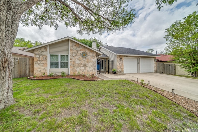 view of front of home with an attached garage, driveway, fence, and stone siding