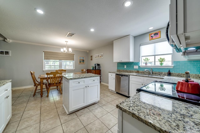 kitchen with a sink, a chandelier, dishwasher, backsplash, and visible vents