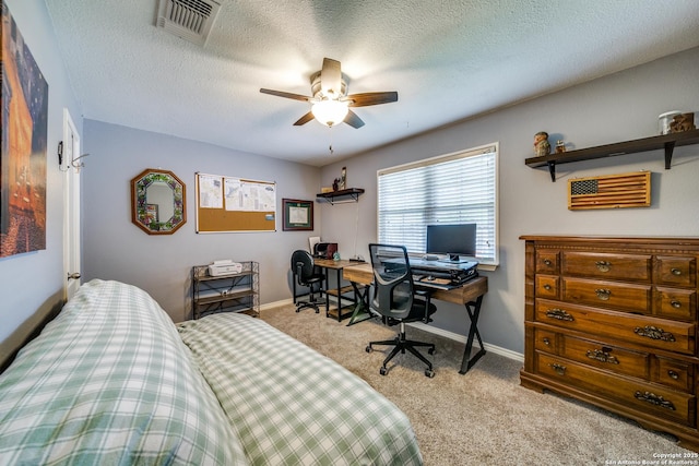 carpeted bedroom featuring a textured ceiling, visible vents, baseboards, and ceiling fan
