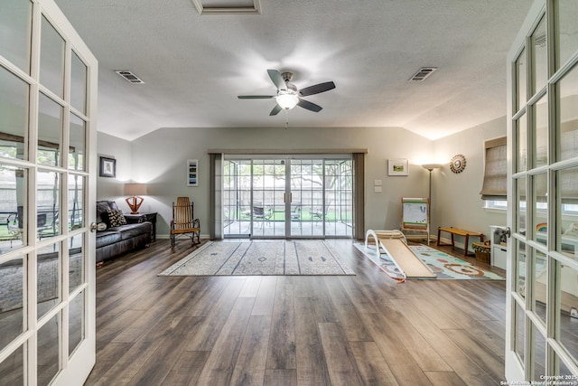 living room with lofted ceiling, a ceiling fan, and visible vents