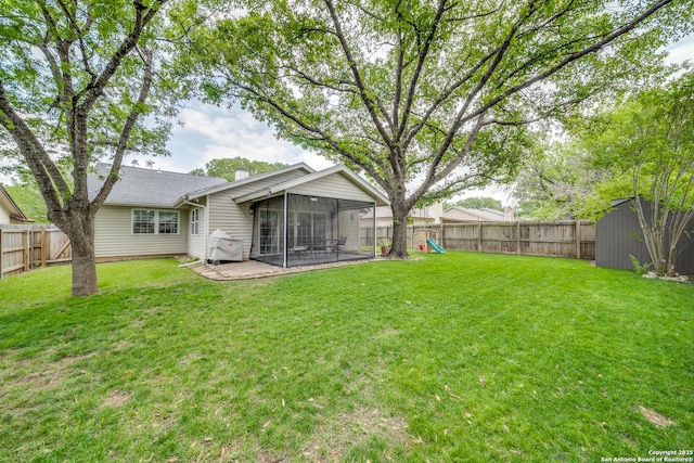 back of house featuring a fenced backyard, a sunroom, and a yard