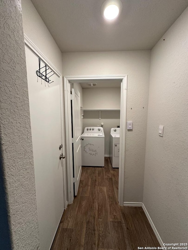 hallway with dark wood finished floors and independent washer and dryer