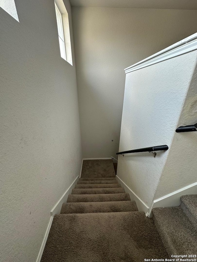 staircase with baseboards and carpet flooring