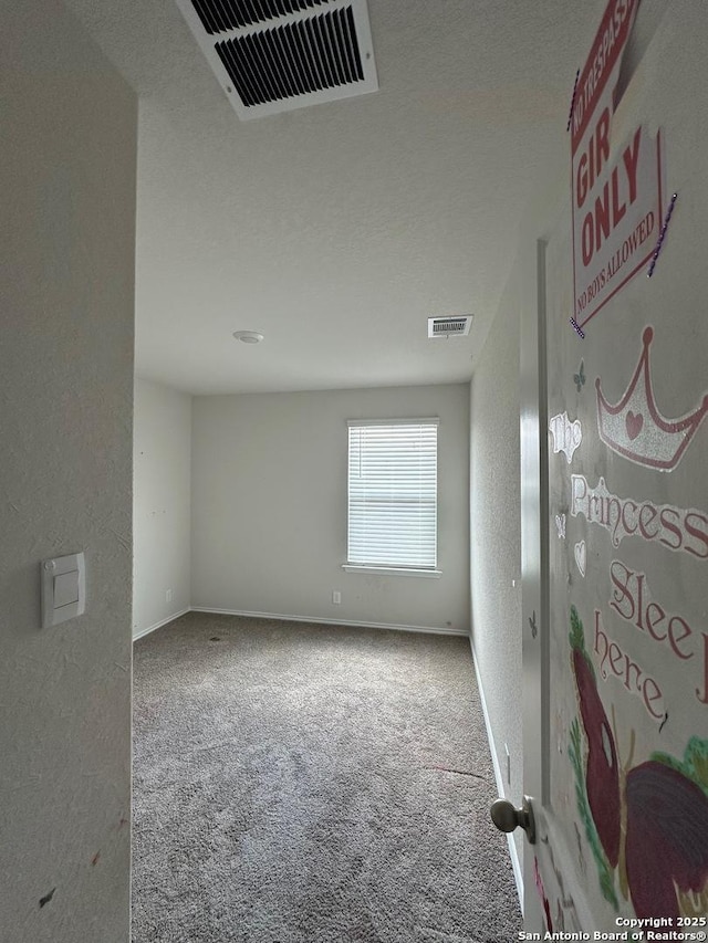 carpeted spare room with baseboards and visible vents