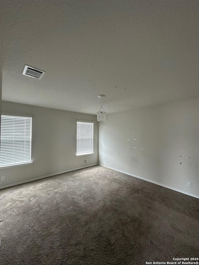 unfurnished room with baseboards, visible vents, and carpet floors