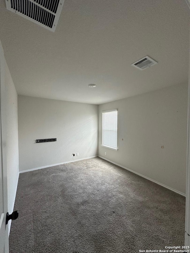 carpeted empty room with visible vents and baseboards