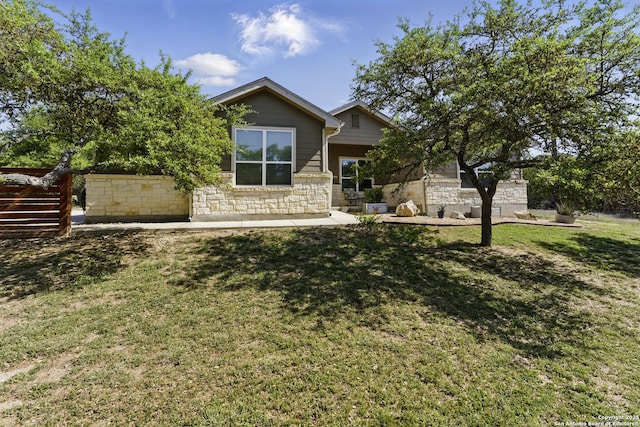 view of front facade featuring stone siding and a front yard