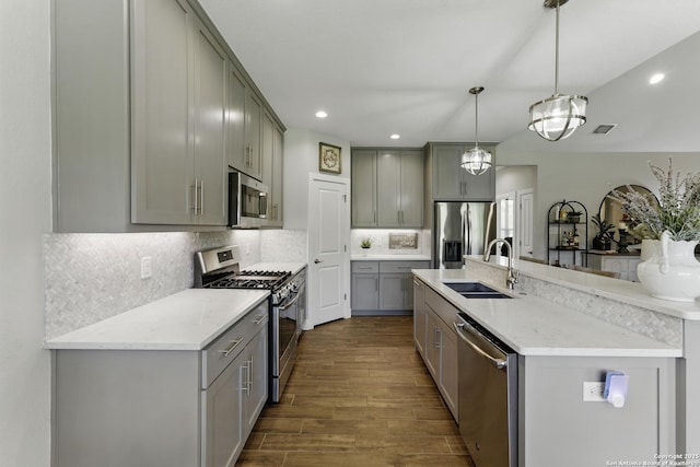 kitchen featuring stainless steel appliances, a sink, dark wood finished floors, visible vents, and gray cabinetry
