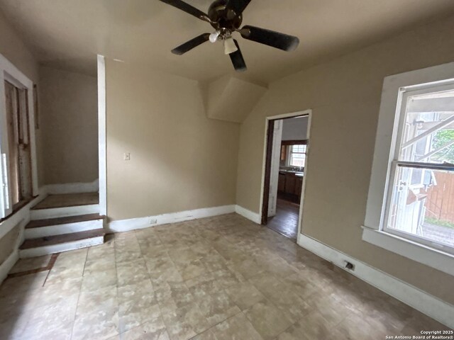 additional living space with a ceiling fan and baseboards