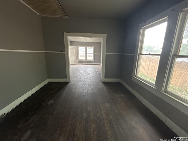 hall featuring baseboards and dark wood-style flooring