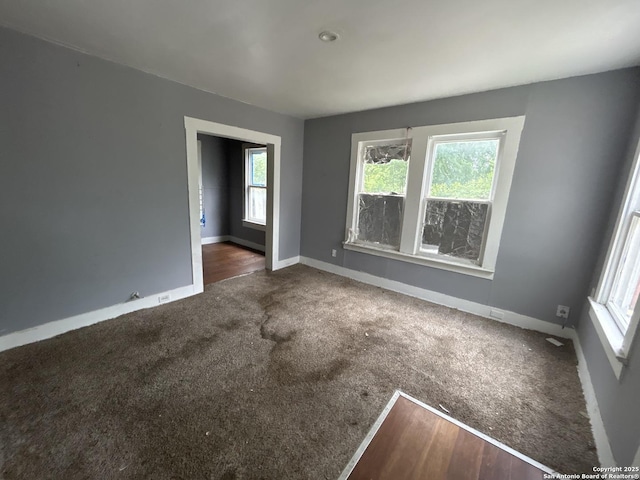 carpeted empty room with baseboards