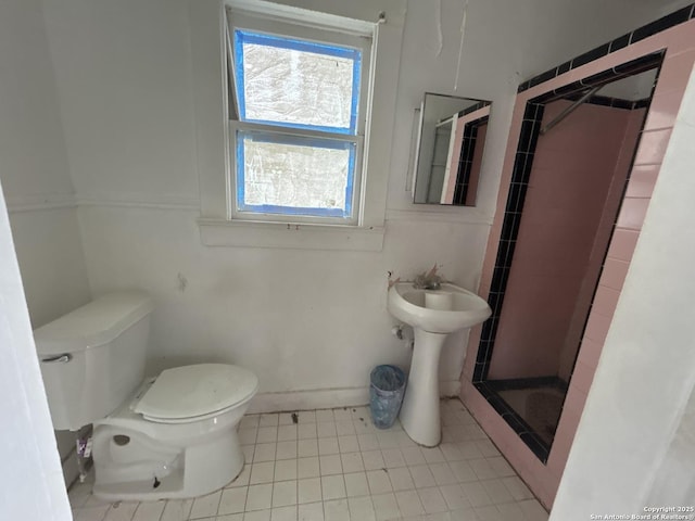 bathroom featuring tile patterned flooring, a shower stall, and toilet