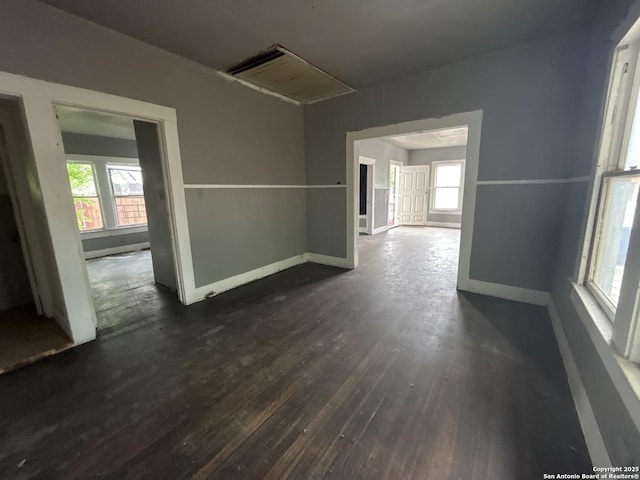 spare room featuring baseboards and dark wood-style flooring