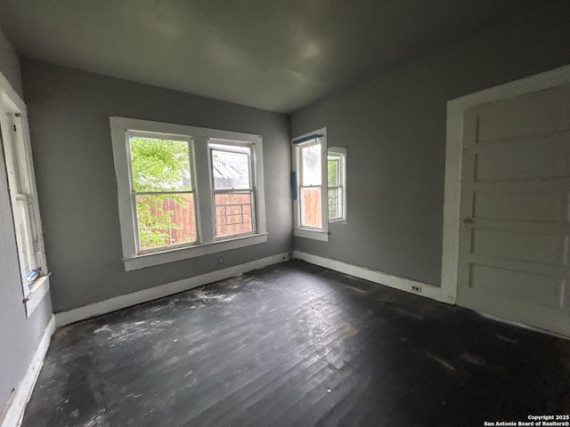 unfurnished room with baseboards