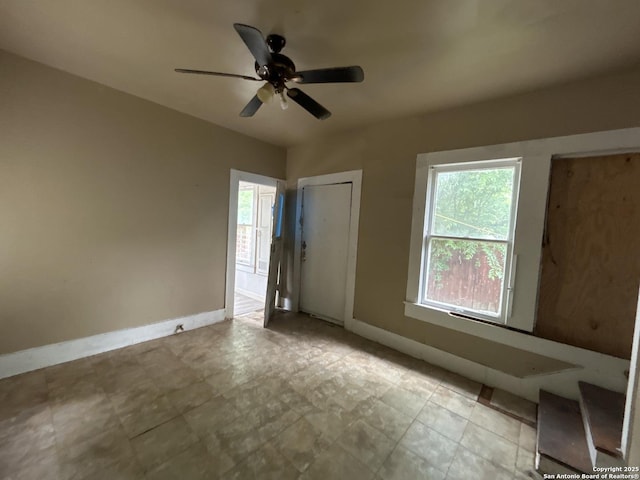 spare room with baseboards and ceiling fan