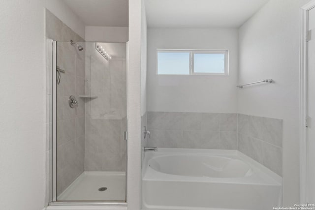 bathroom featuring a garden tub and a shower stall