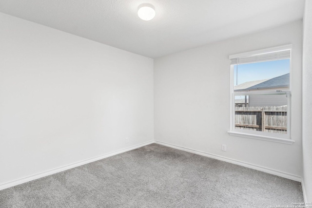 unfurnished room with baseboards and carpet flooring