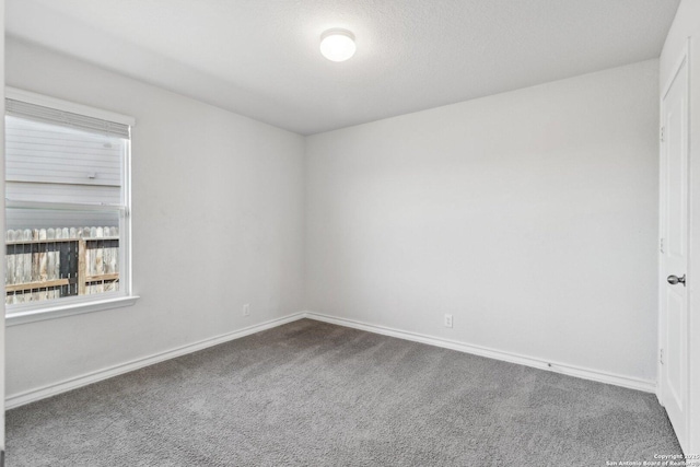 unfurnished room featuring carpet and baseboards