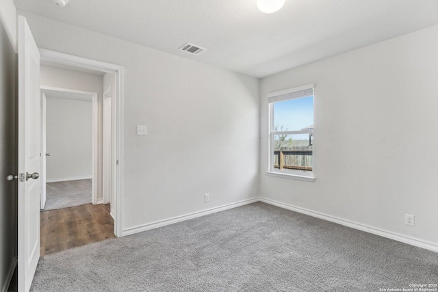 carpeted spare room with baseboards and visible vents