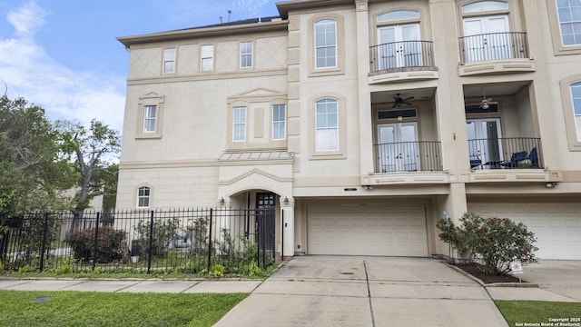 multi unit property with a garage, french doors, a balcony, and stucco siding