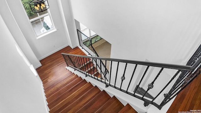 staircase featuring baseboards and wood finished floors