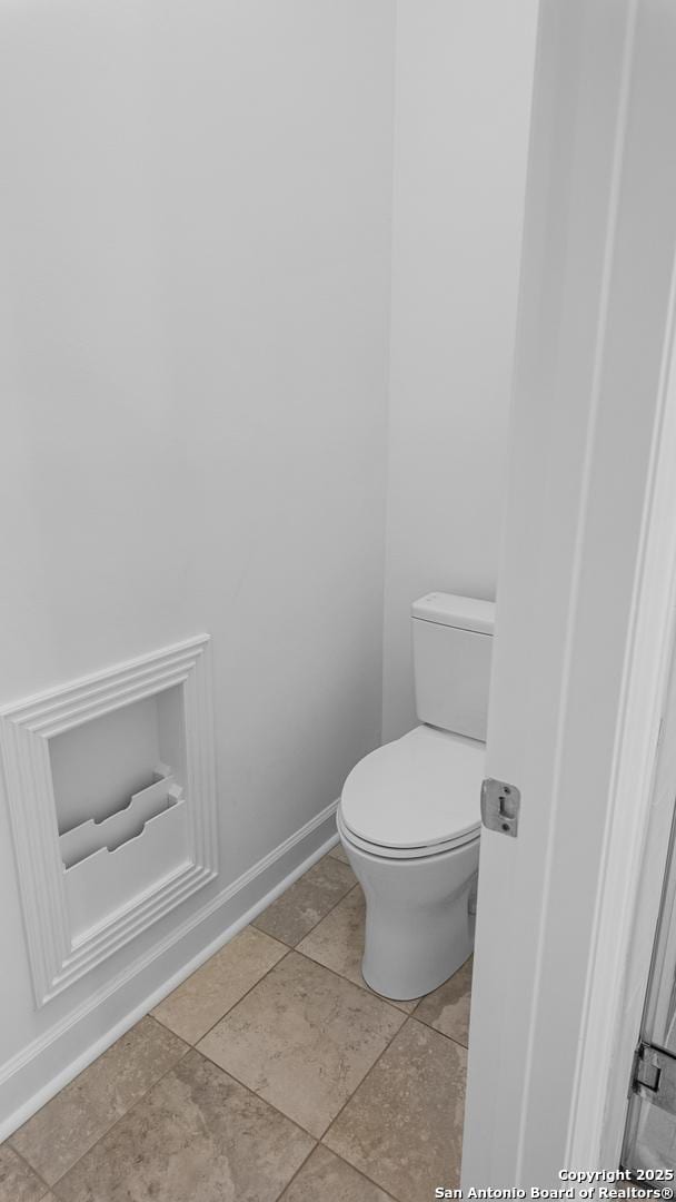 bathroom with toilet and baseboards