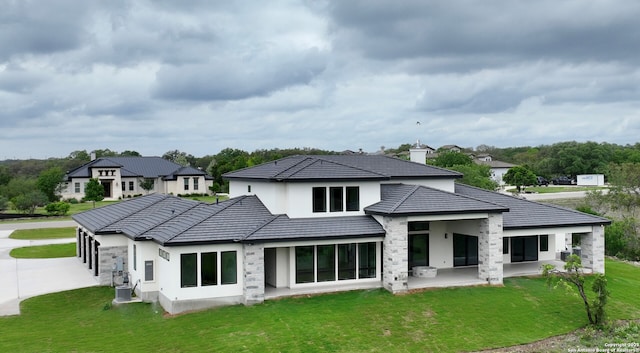back of house with a patio, a lawn, central air condition unit, and stucco siding