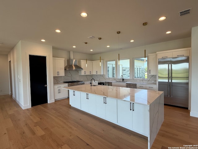 kitchen featuring visible vents, a spacious island, light wood-type flooring, white cabinetry, and stainless steel appliances