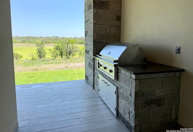 view of patio with area for grilling, a rural view, and a wooden deck
