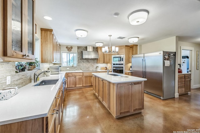 kitchen with light countertops, wall chimney range hood, a sink, concrete floors, and appliances with stainless steel finishes